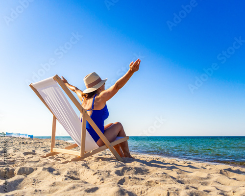 Woman relaxing on beach sitting on sunbed
