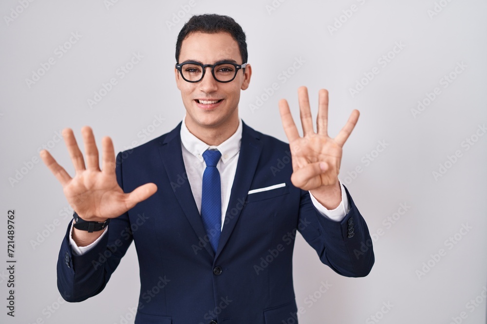 Young hispanic man wearing suit and tie showing and pointing up with fingers number nine while smiling confident and happy. Young hispanic man wearing suit and tie showing and pointing up with fingers number nine while smiling confident and happy.