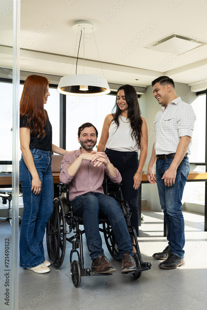 Man in a wheelchair feeling welcome and supported by their team members at an inclusive office
