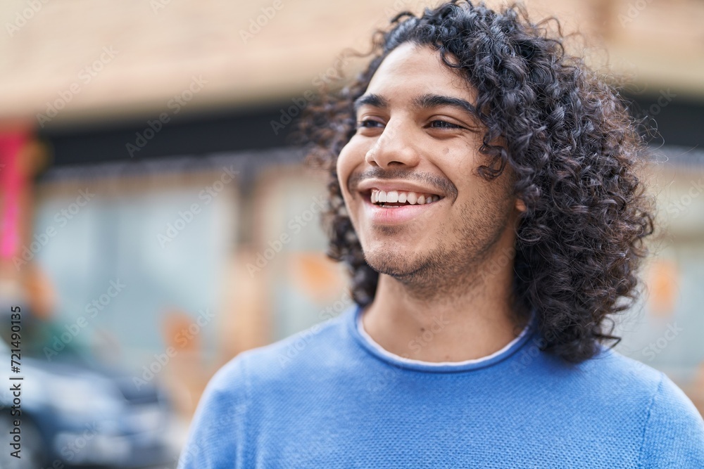 Young latin man smiling confident looking to the side at street