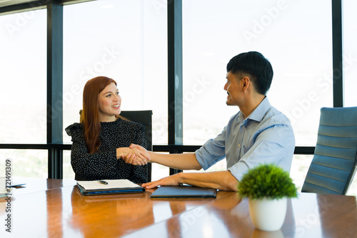 Caucasian woman closing a deal with a client and shaking hands