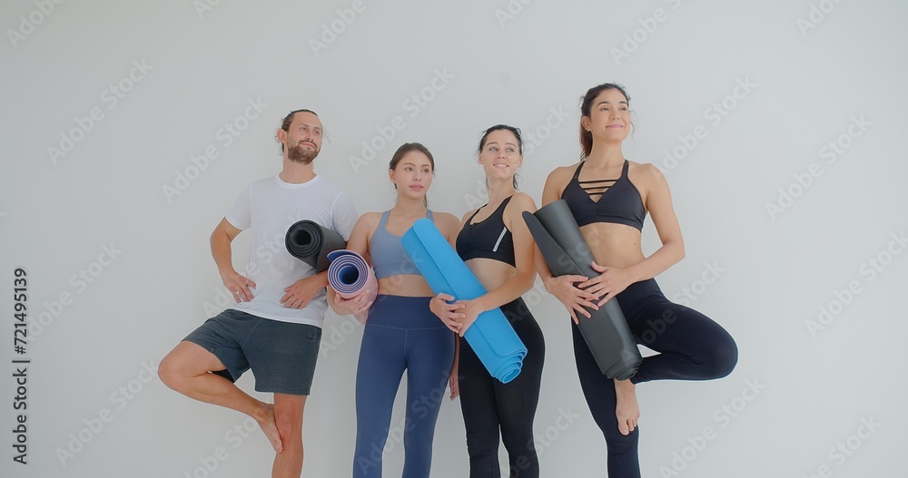 Obraz premium group of woman and man standing leaned on wall waiting for yoga class, before or after work out people in sportswear holds yoga mats looking happy and healthy, well-being, sports wellness concept