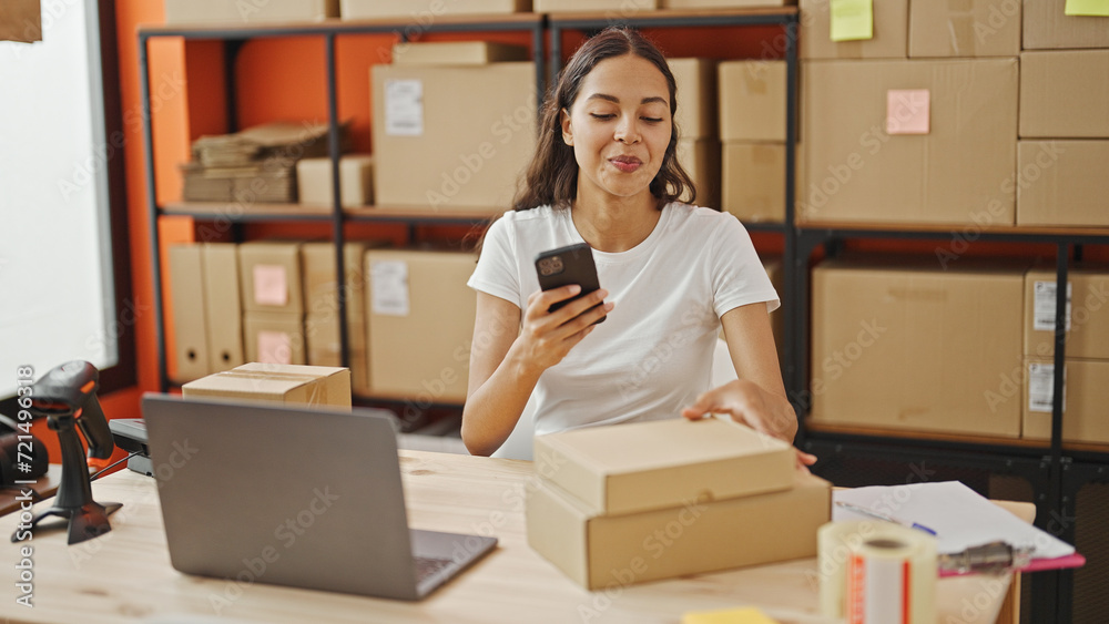African american woman ecommerce business worker make photo to packages by smartphone at office