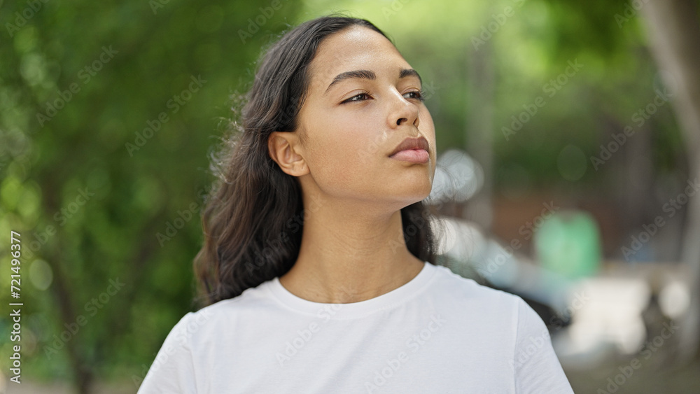 African american woman looking to the side with serious expression at park African american woman looking to the side with serious expression at park
