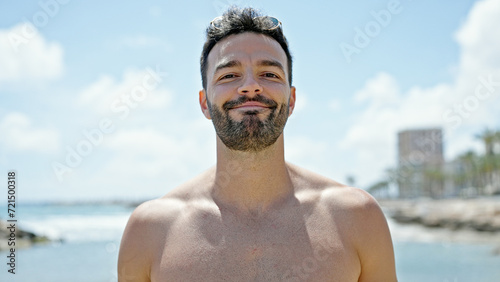 Young hispanic man tourist smiling confident shirtless at the beach