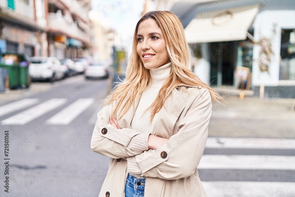 Fototapeta premium Young blonde woman standing with arms crossed gesture at street