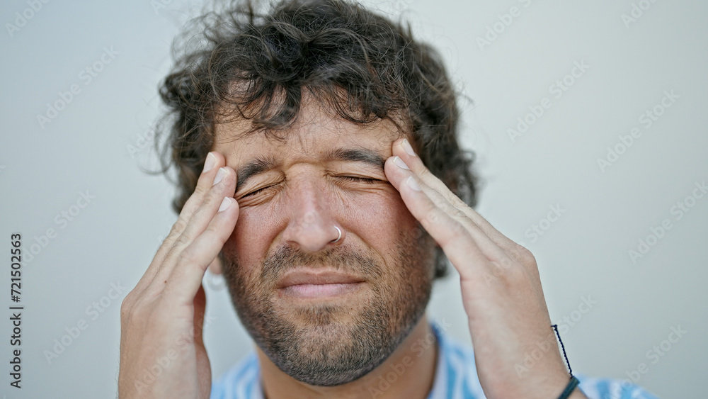 Young hispanic man suffering for headache over isolated white background Young hispanic man suffering for headache over isolated white background