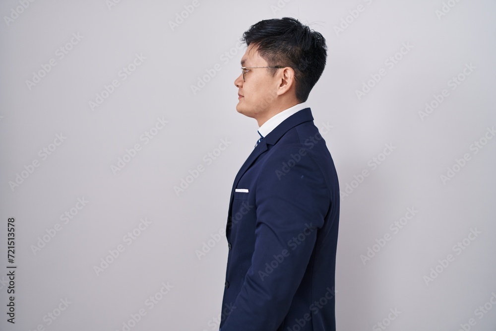 Young asian man wearing business suit and tie looking to side, relax profile pose with natural face and confident smile. Young asian man wearing business suit and tie looking to side, relax profile pose with natural face and confident smile.