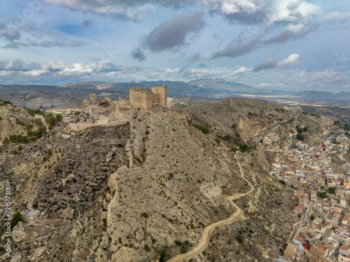 Aerial panorama view of Castillo de los Velez, medieval ruined castle perched on top of Mula, keep, well tower, machicolation, Parroquia Mayor De Santo Domingo De Guzmán church, 