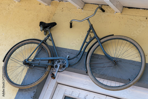 old bicycle hung on the wall of a house