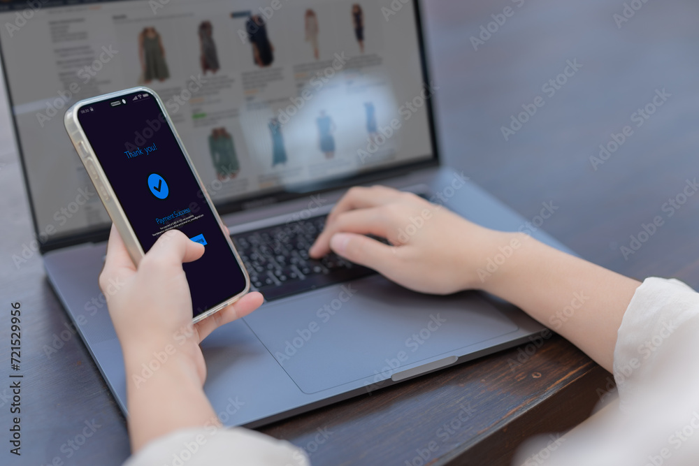 Online shopping concept, Woman hands holding using  smartphone making online payment with laptop