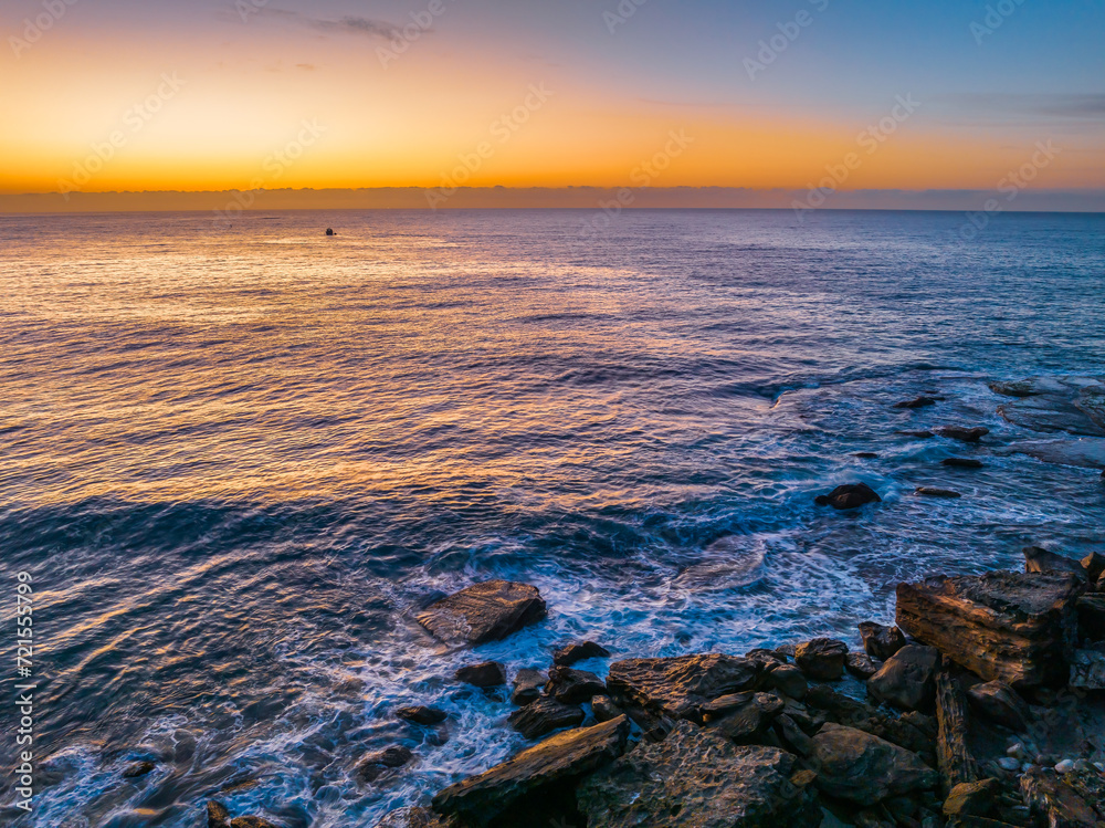 Naklejka premium Pretty blue sunrise at the beach with calm seas