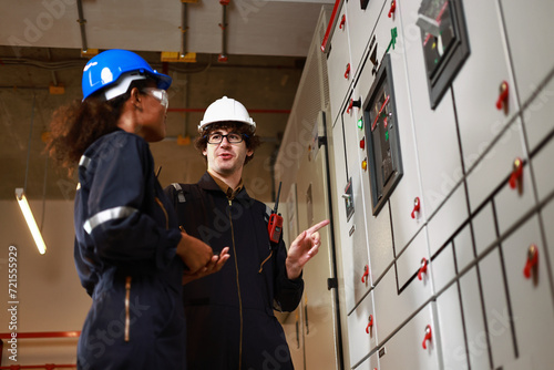 Male and Female electrical engineer working in electrical control room, Main Distribution Board photo