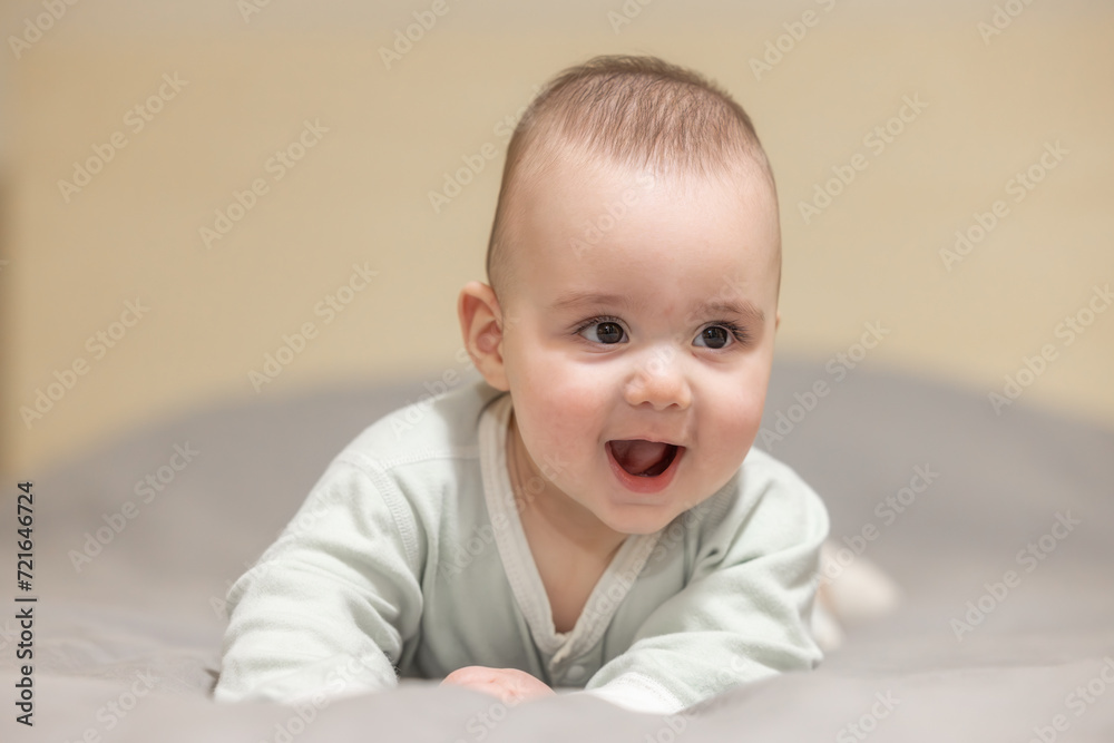 Baby boy on a bed smiling and happy. Close up portrait