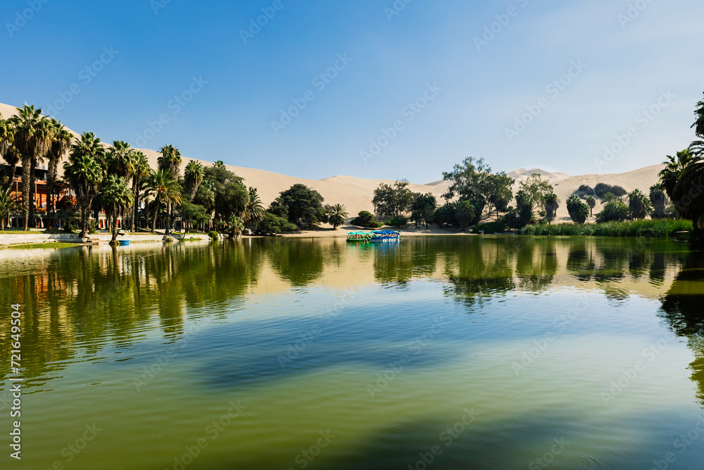 Oasis of Huacachina near Ica city in Peru. Lake and trees inside the dunes. Travel destination in South American