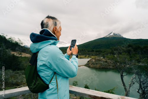 Wallpaper Mural tourist in Bahia Lapataia amidst mountains at Tierra del Fuego Torontodigital.ca