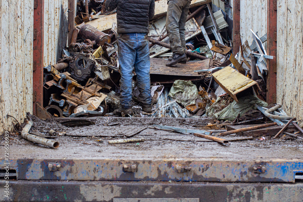 Obraz premium scales with metal at the reception of recyclable materials for recycling and people helping to load them into a container