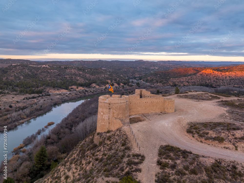 Aerial colorful sky sunset panoramic view of Flix new castle above the Ebro river in Spain with triangular shape circular gun platforms
