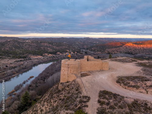 Obraz na płótnie Aerial colorful sky sunset panoramic view of Flix new castle above the Ebro river in Spain with triangular shape circular gun platforms w salonie