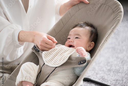 Fotografía ニコニコあやされるバウンサーにのるかわいい笑顔の赤ちゃん
