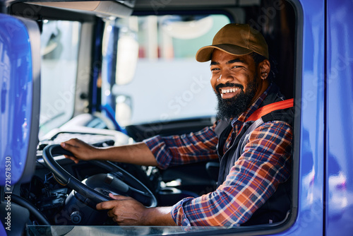 Happy black driver driving his truck and looking at camera. photo