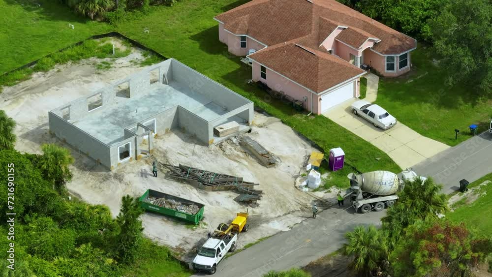 New home under construction. Unfinished frame of private house with brick concrete walls ready for mounting wooden roof beams