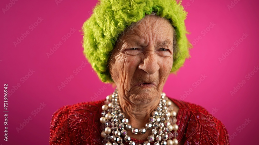Funny fisheye view of sad, unhappy, confused, mature woman with no teeth saying NO, does not understand wearing green hat isolated on pink background. Funny fisheye view of sad, unhappy, confused, mature woman with no teeth saying NO, does not understand wearing green hat isolated on pink background.