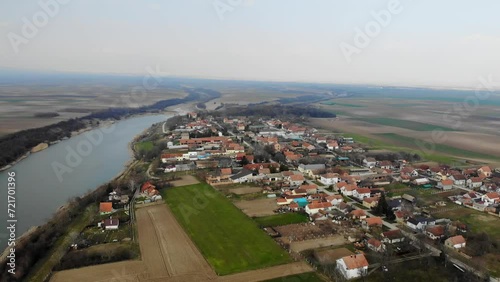 Drone footage of small houses in village Jarkovci in plain countryside near lake photo