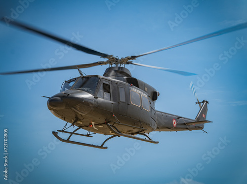 military helicopter in flight supporting ground personnel 