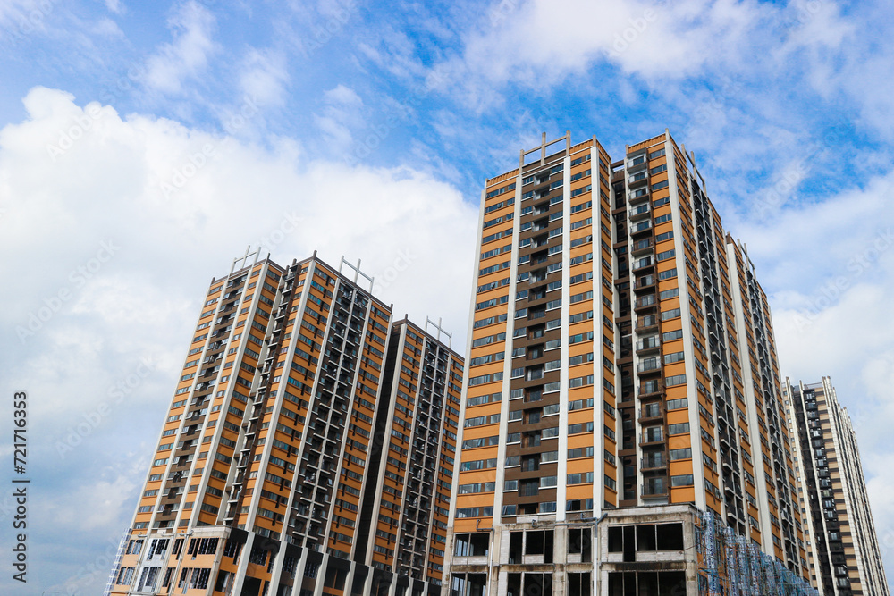 Front up view of modern residential apartement building with blue sky in background Front up view of modern residential apartement building with blue sky in background