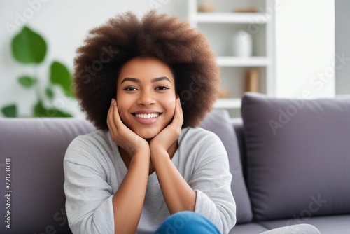 Happy afro american woman relaxing on the sofa at home - Smiling girl enjoying day off lying on the couch. Generative AI - 1 photo