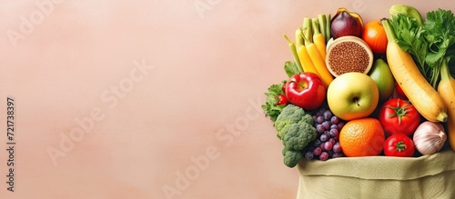 Healthy food selection. a Shopping bags full of fresh vegetables and fruits. Food lying flat on the table  pink color background  a lot of copy space