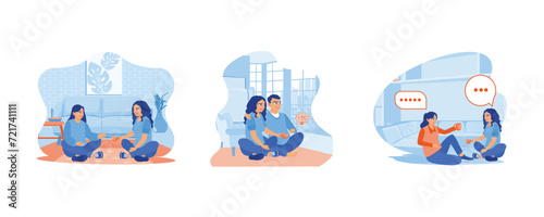 A young couple is sitting on the floor inside the house. Drink tea while chatting together. Two young women are discussing while drinking tea together. Smiling woman friends drinking tea at home conce