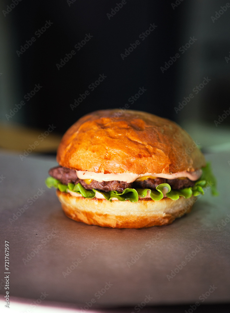 Fresh tasty burger on dark background. Soft focus. Vertical photo. High quality photo Fresh tasty burger on dark background. Soft focus. Vertical photo. High quality photo