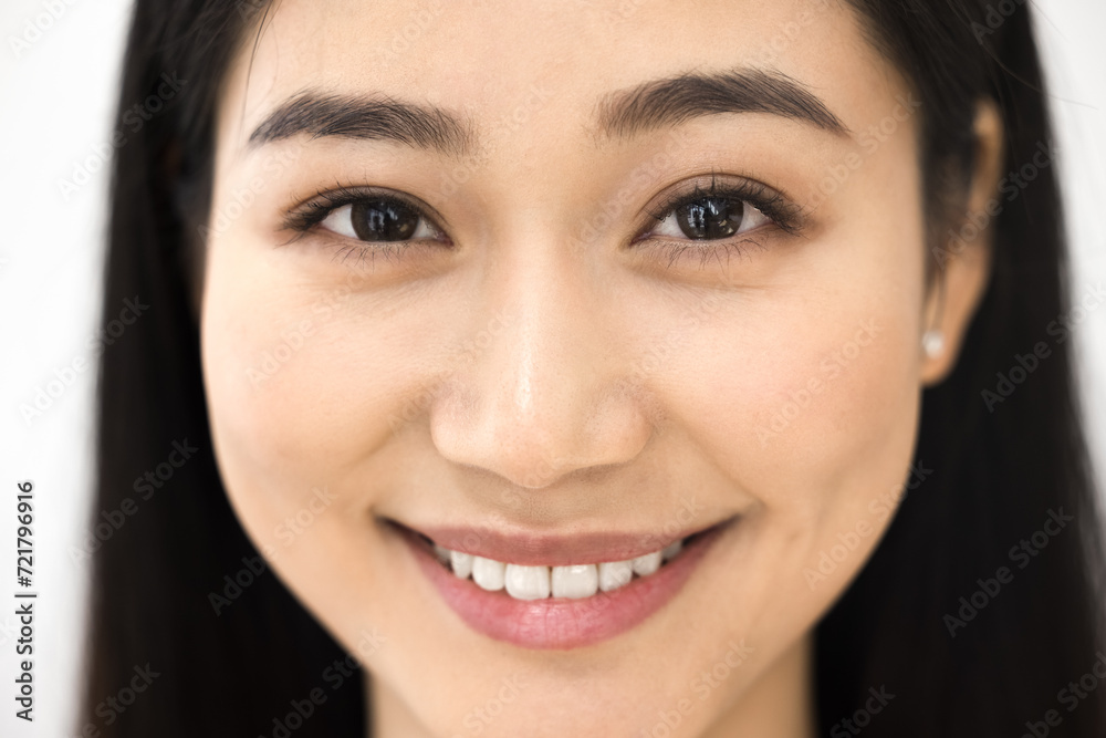 Cheerful beautiful young Asian woman face close up. Happy beauty care model girl with smooth perfect facial skin and toothy smile looking at camera, posing for cropped portrait Cheerful beautiful young Asian woman face close up. Happy beauty care model girl with smooth perfect facial skin and toothy smile looking at camera, posing for cropped portrait