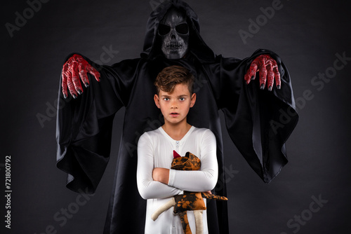 Little boy in white pajamas unaware that a scary monster is standing behind him photo