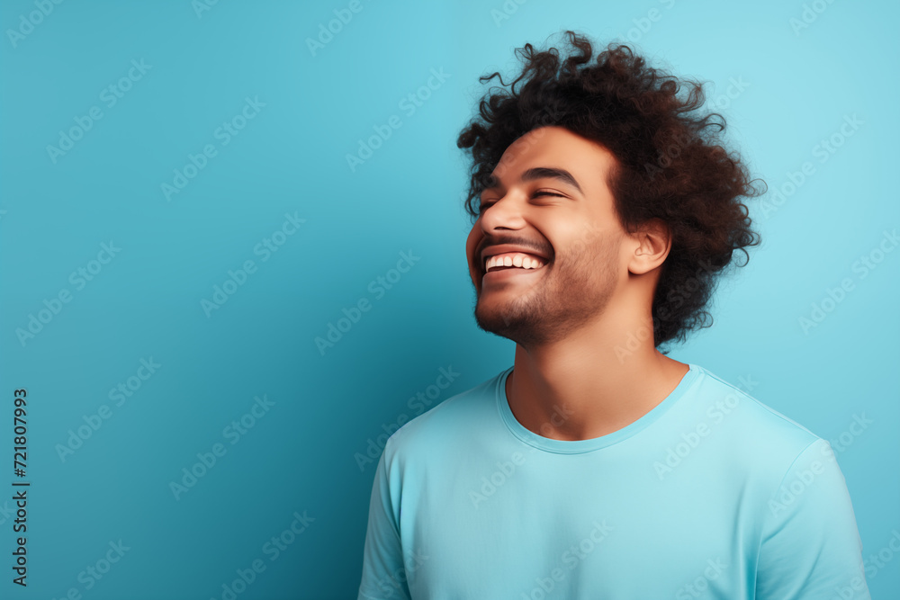 The young boy laughed with a natural smile on his face. blue background. Y001 The young boy laughed with a natural smile on his face. blue background. Y001