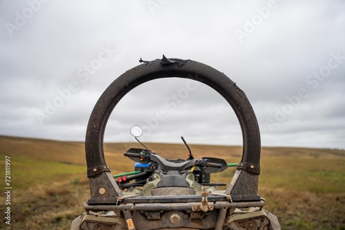 quad bike with a crush protection rollbar installed for safety in australia. australian motorbike in a field on a farm photo