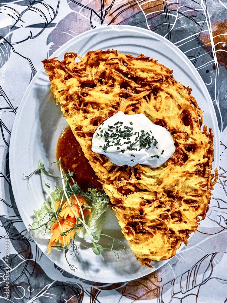 Baked potatoes with cheese and meat on a plate in a restaurant