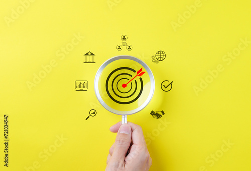 Business growth and marketing target concepts. Holding a magnifying glass with aim bullseye icon and other business icons. Goal objective strategy plan action, Target success, Achievement company, photo