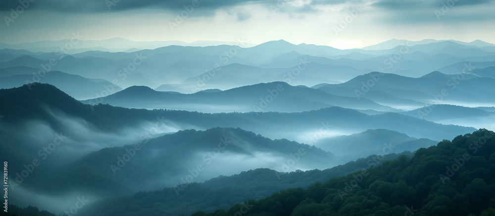 Misty mountains layered in shades of blue at dawn.