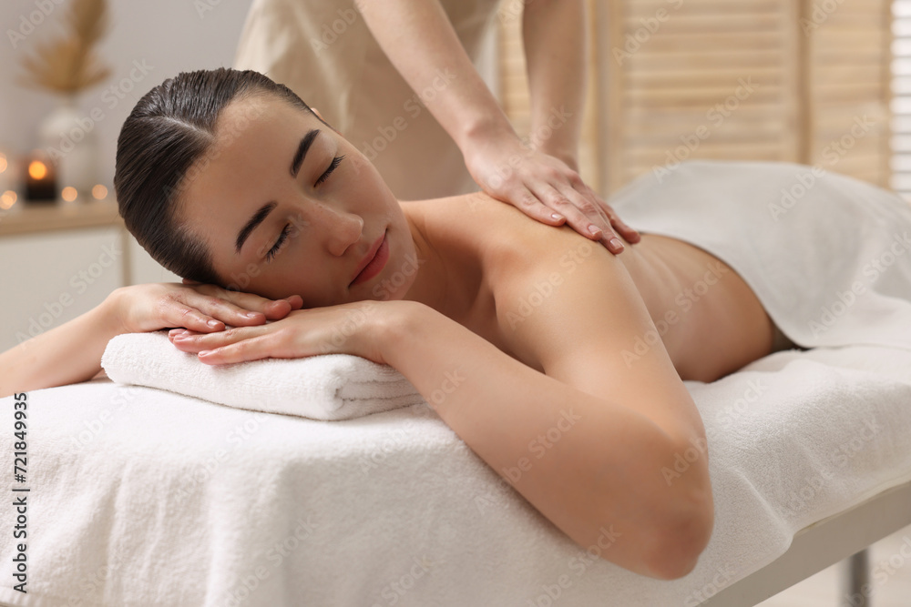 Obraz premium Woman receiving back massage on couch in spa salon