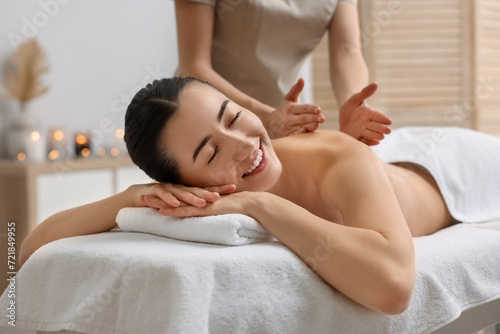 Woman receiving back massage on couch in spa salon