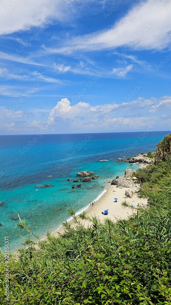 Embark on a visual journey to Calabria's enchanting beach, where golden sands meet the azure sea in perfect harmony. Crystal-clear waters invite you to immerse yourself in a summer haven.