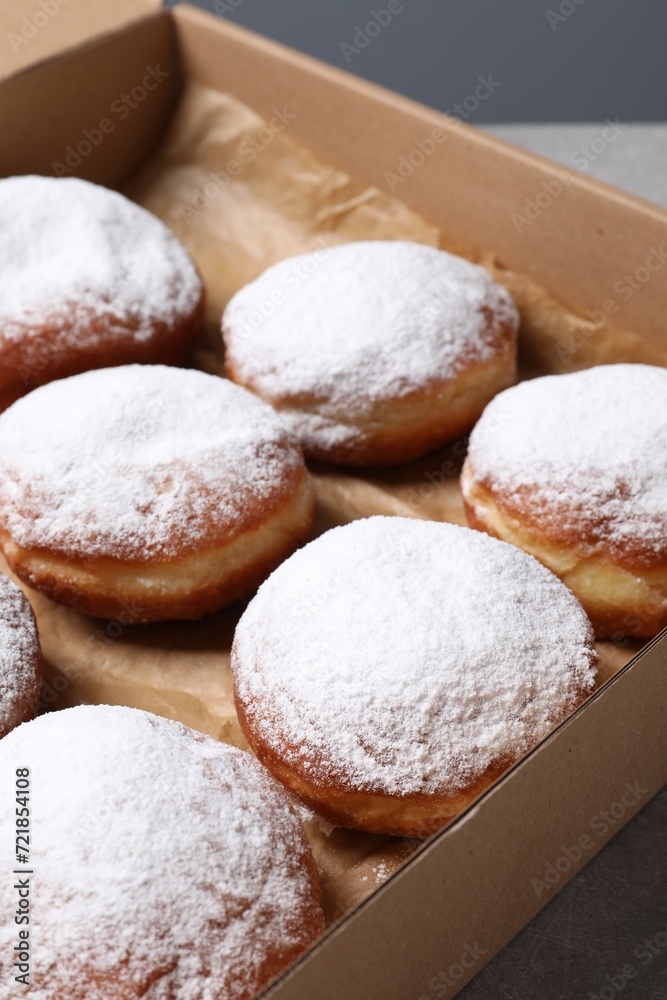 Delicious buns with powdered sugar on table, closeup