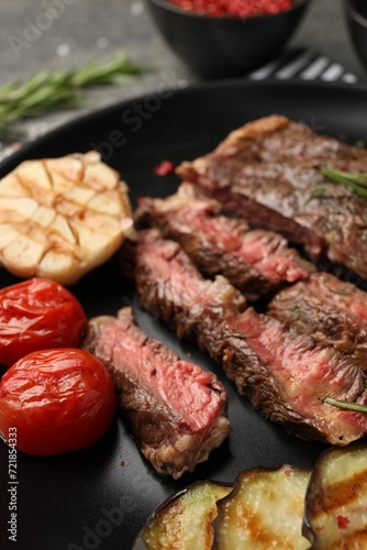 Delicious grilled beef steak with vegetables and spices on plate, closeup