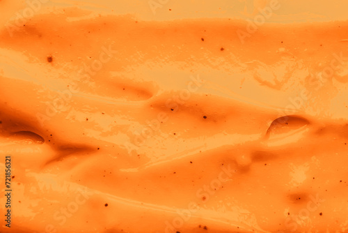 Texture of body cream as background, closeup. Toned in orange