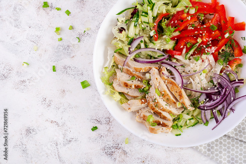 Fresh salad with grilled chicken breast, fillet and lettuce, daikon, red onions, cucumber and sesame. Healthy lunch menu. Diet food. Top view