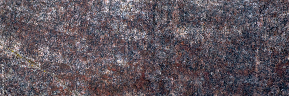 Red granite texture. A variegated, spotted background of red with dark gray rough granite. The stone granite surface of brown-gray color. Surface view of granular igneous rock Red granite texture. A variegated, spotted background of red with dark gray rough granite. The stone granite surface of brown-gray color. Surface view of granular igneous rock