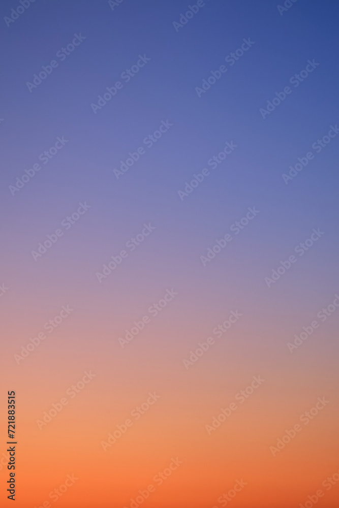 Gradient of sunset sky from red-orange to blue, vertical photo